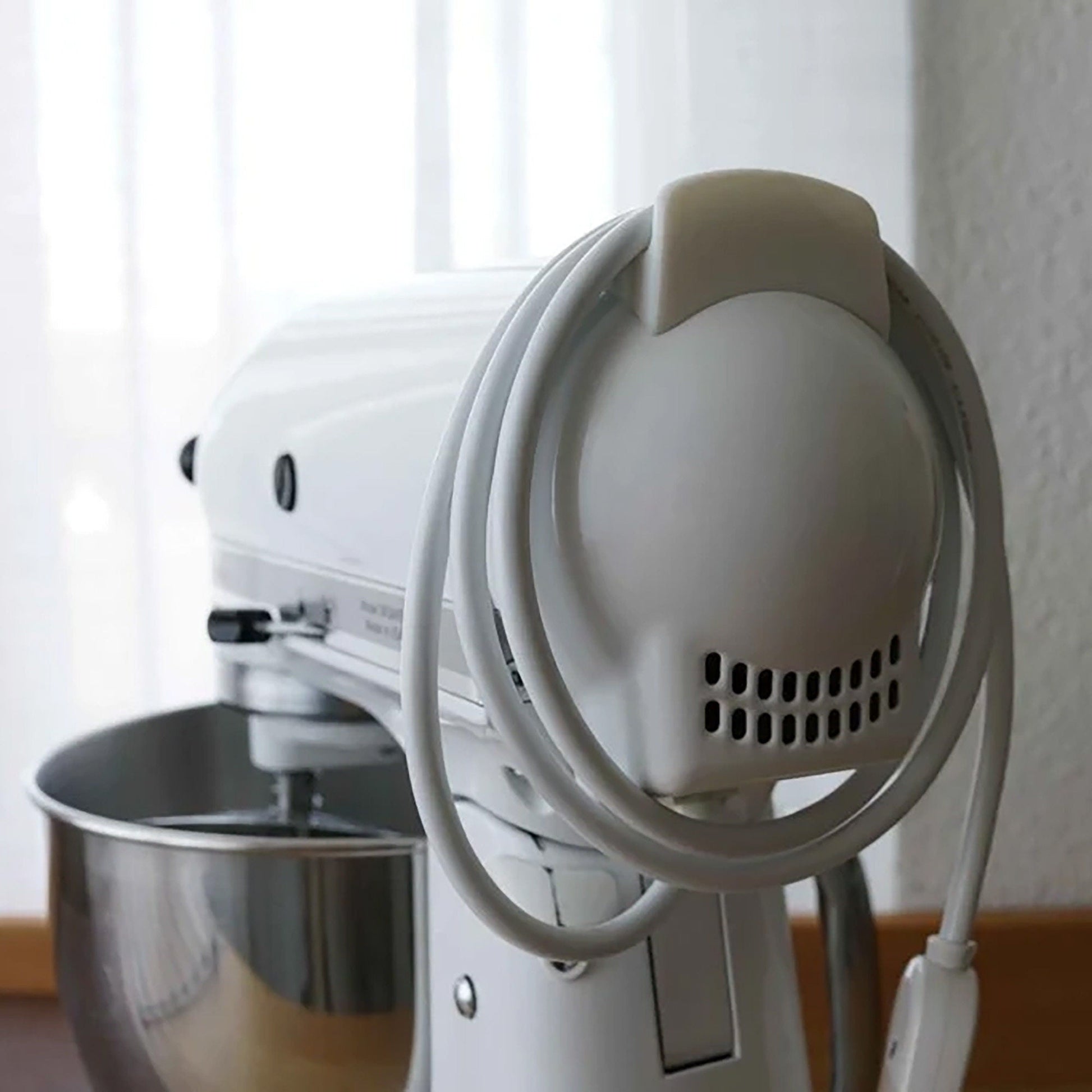 a white mixer sitting on top of a wooden table