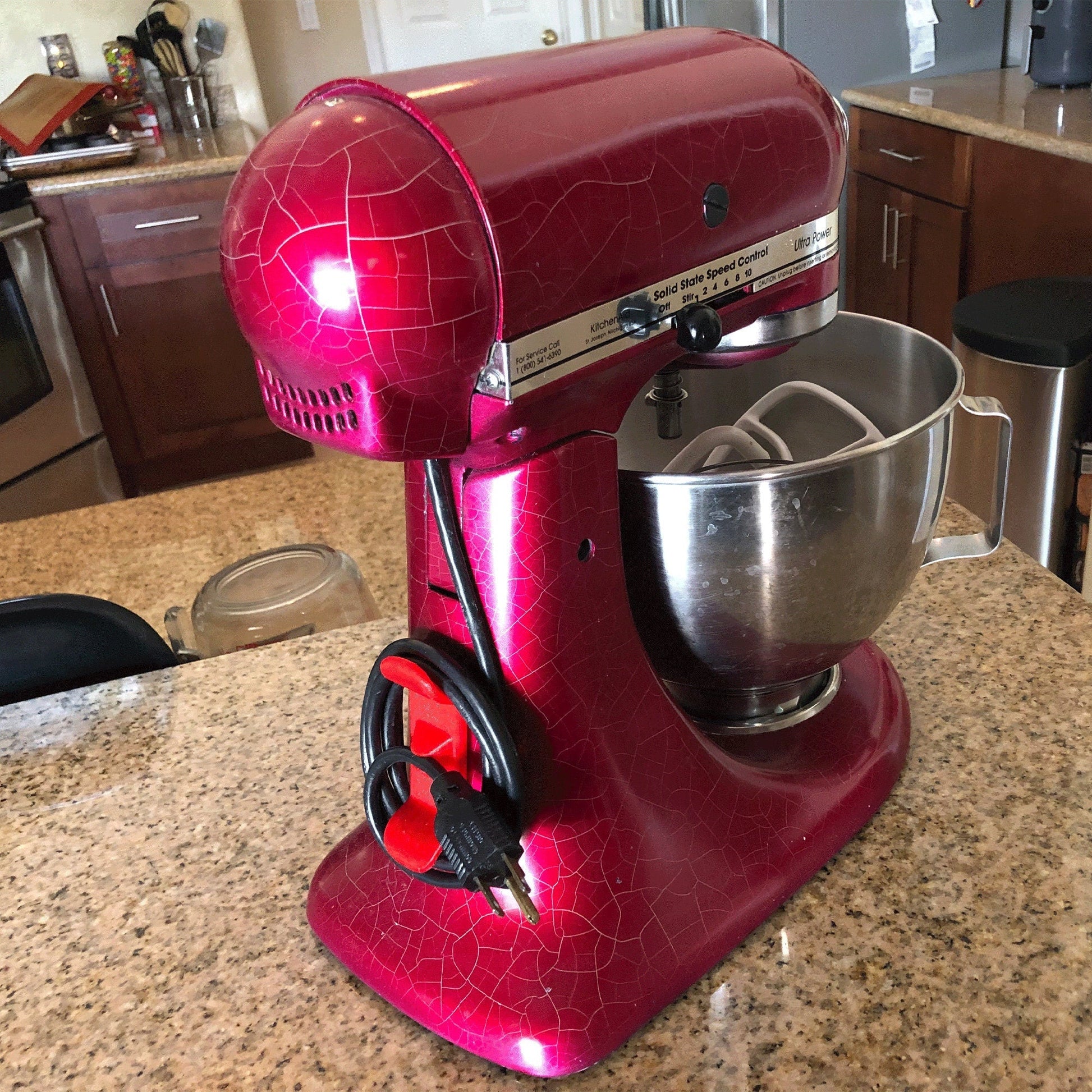 a red mixer sitting on top of a kitchen counter