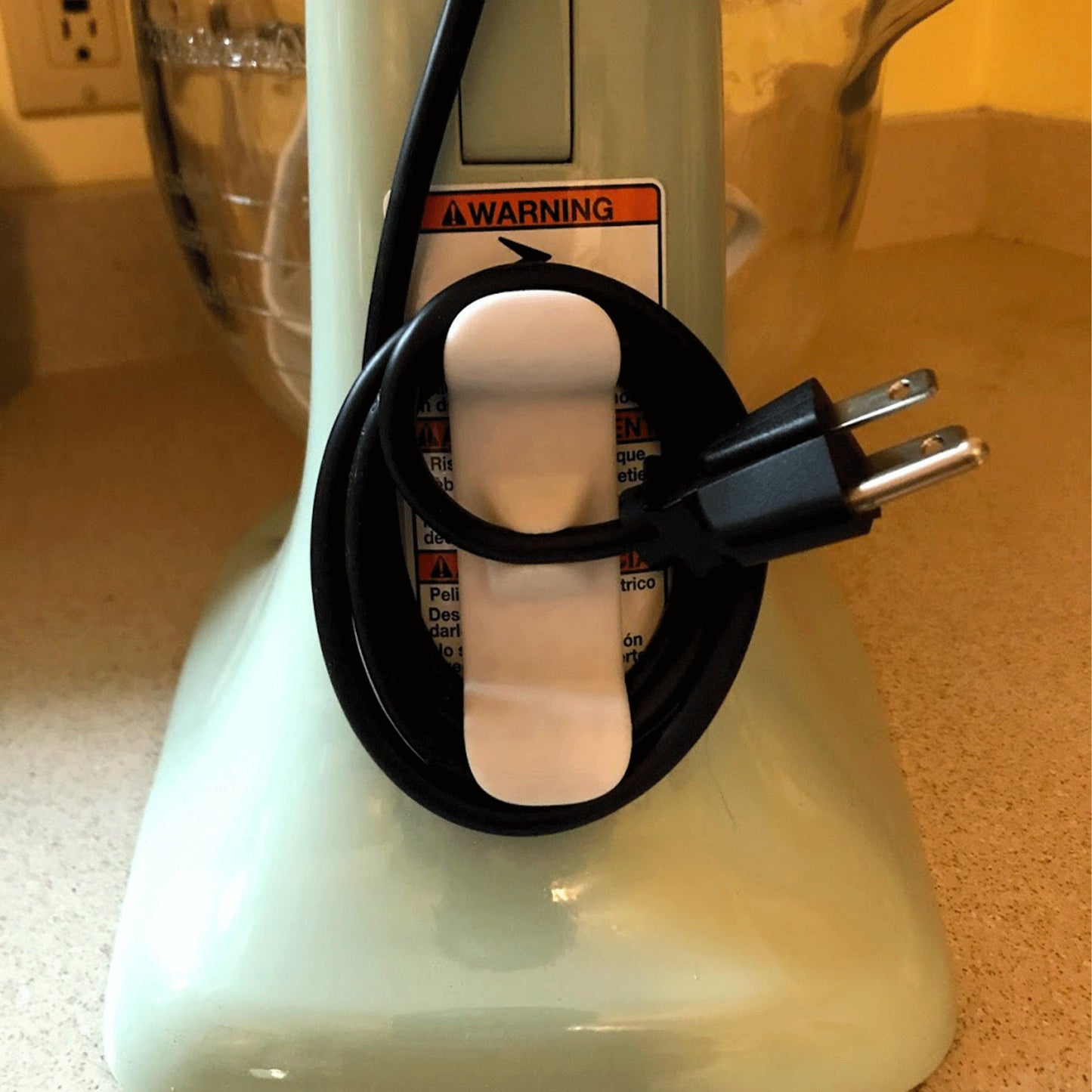 a close up of a blender with a cord plugged into it