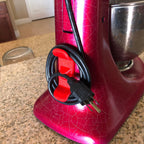 Adhesive twin-prong cord cleat on the back of a KitchenAid stand mixer, view 2