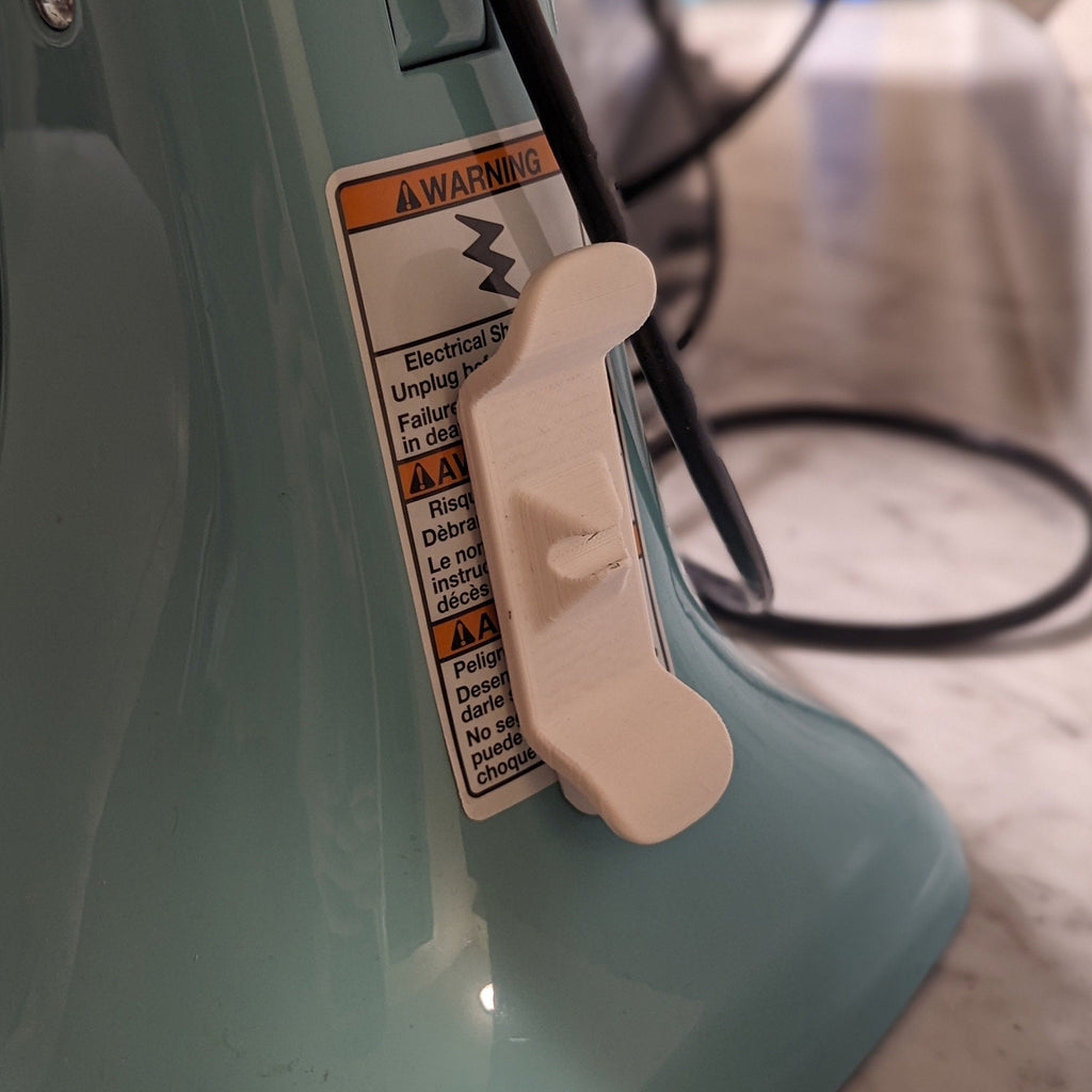 Adhesive twin-prong cord cleat on the back of a KitchenAid stand mixer, view 5