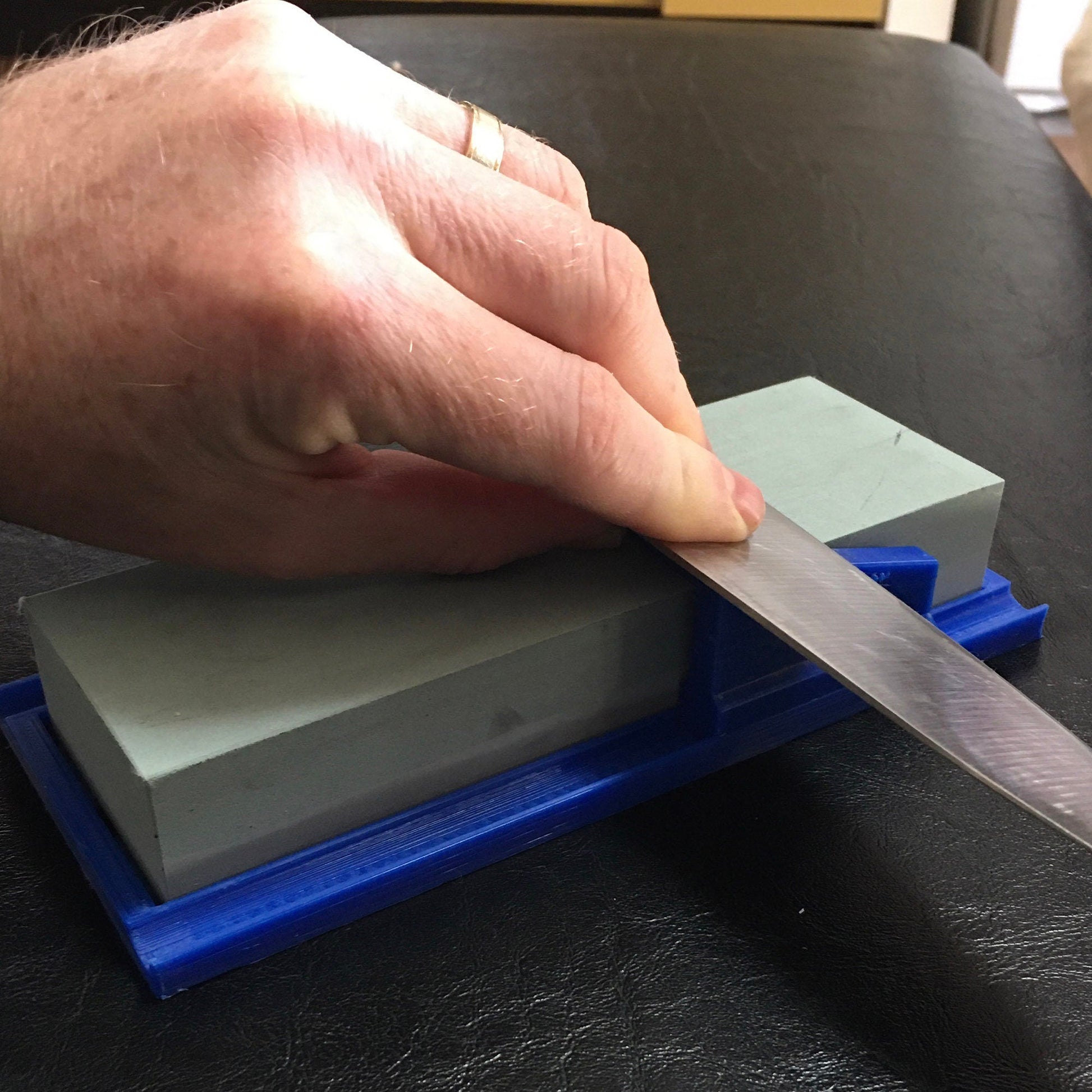 a person cutting a piece of plastic with a knife