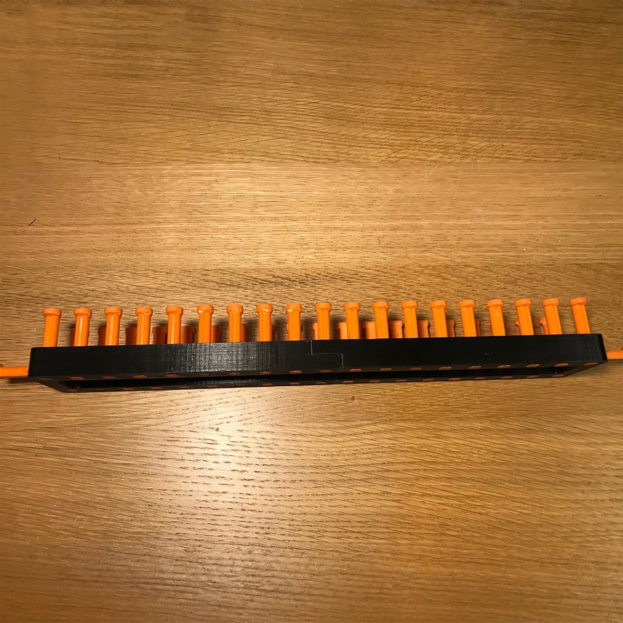 a wooden table with a black and orange comb on it