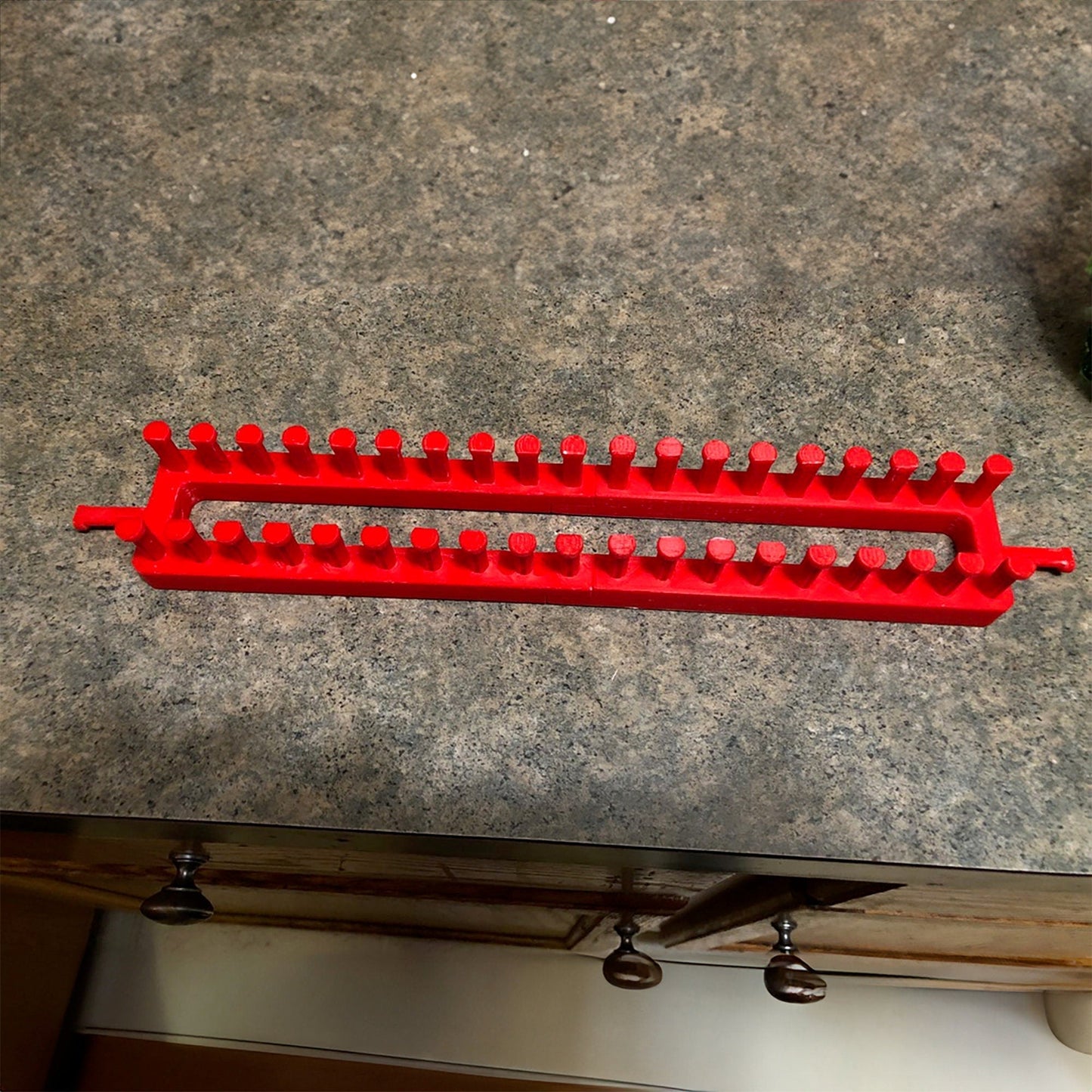 a red plastic object sitting on top of a counter