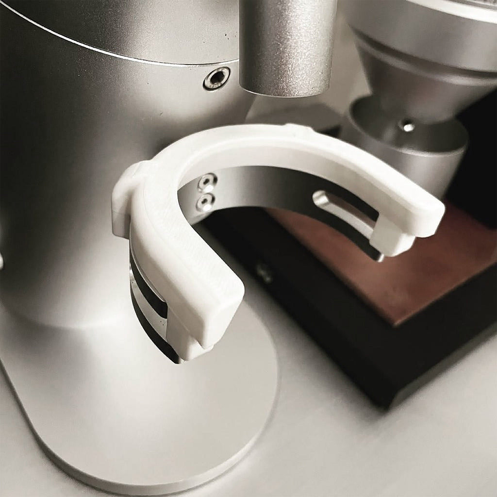 Dosing cup holder adapter mounted under the spout of a Lagom P64 grinder, view 2