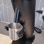 Dosing cup holder adapter mounted under the spout of a Lagom P64 grinder, view 3