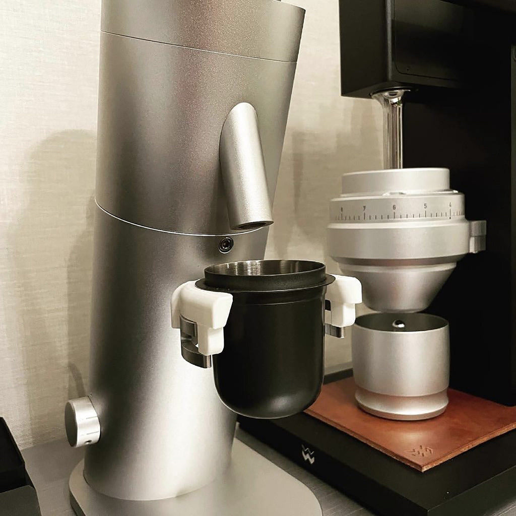 Dosing cup holder adapter mounted under the spout of a Lagom P64 grinder
