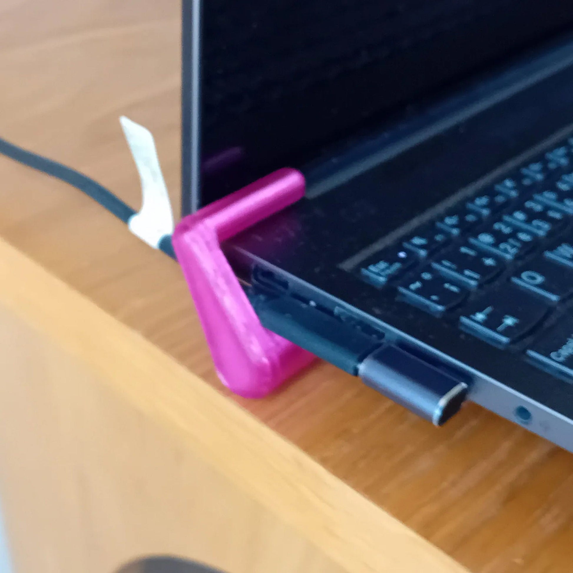 a pink piece of plastic sitting on top of a laptop computer