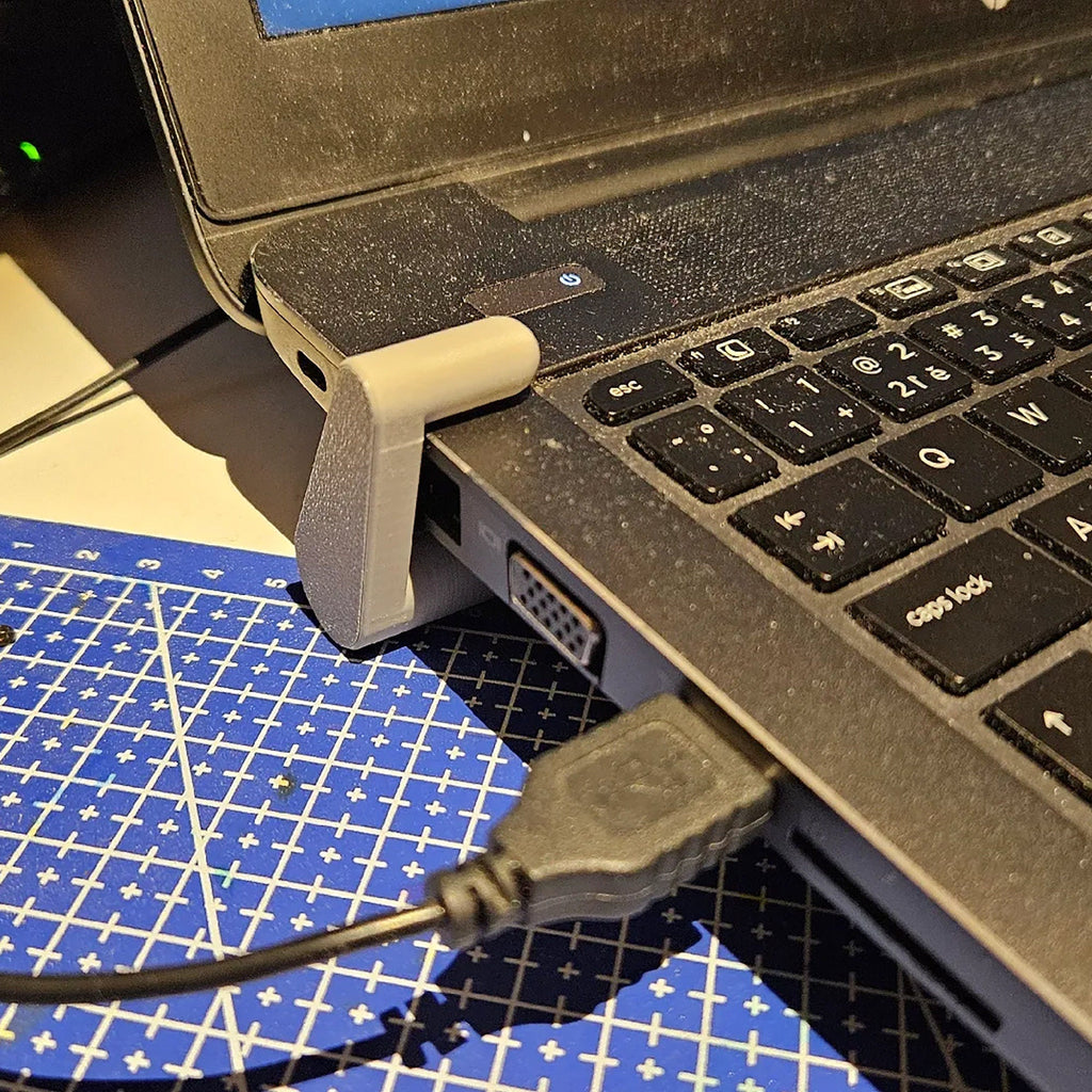 Clip-on laptop riser feet lifting the rear edge of a laptop for airflow, view 3
