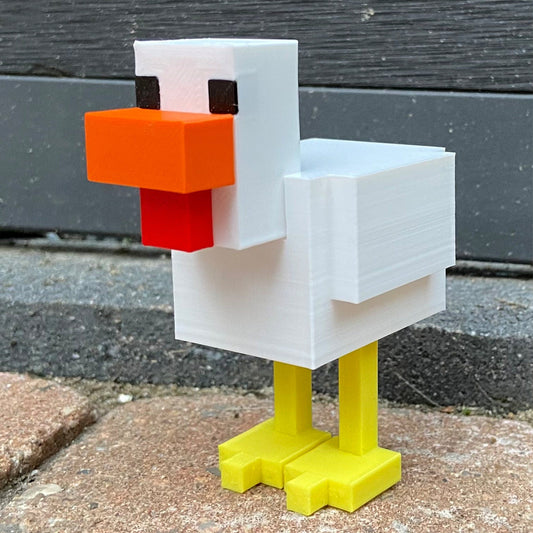 a lego duck is standing on a sidewalk