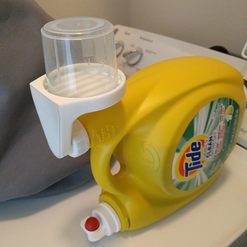 Detergent cup drip catcher on a Tide laundry bottle spout holding the measuring cup