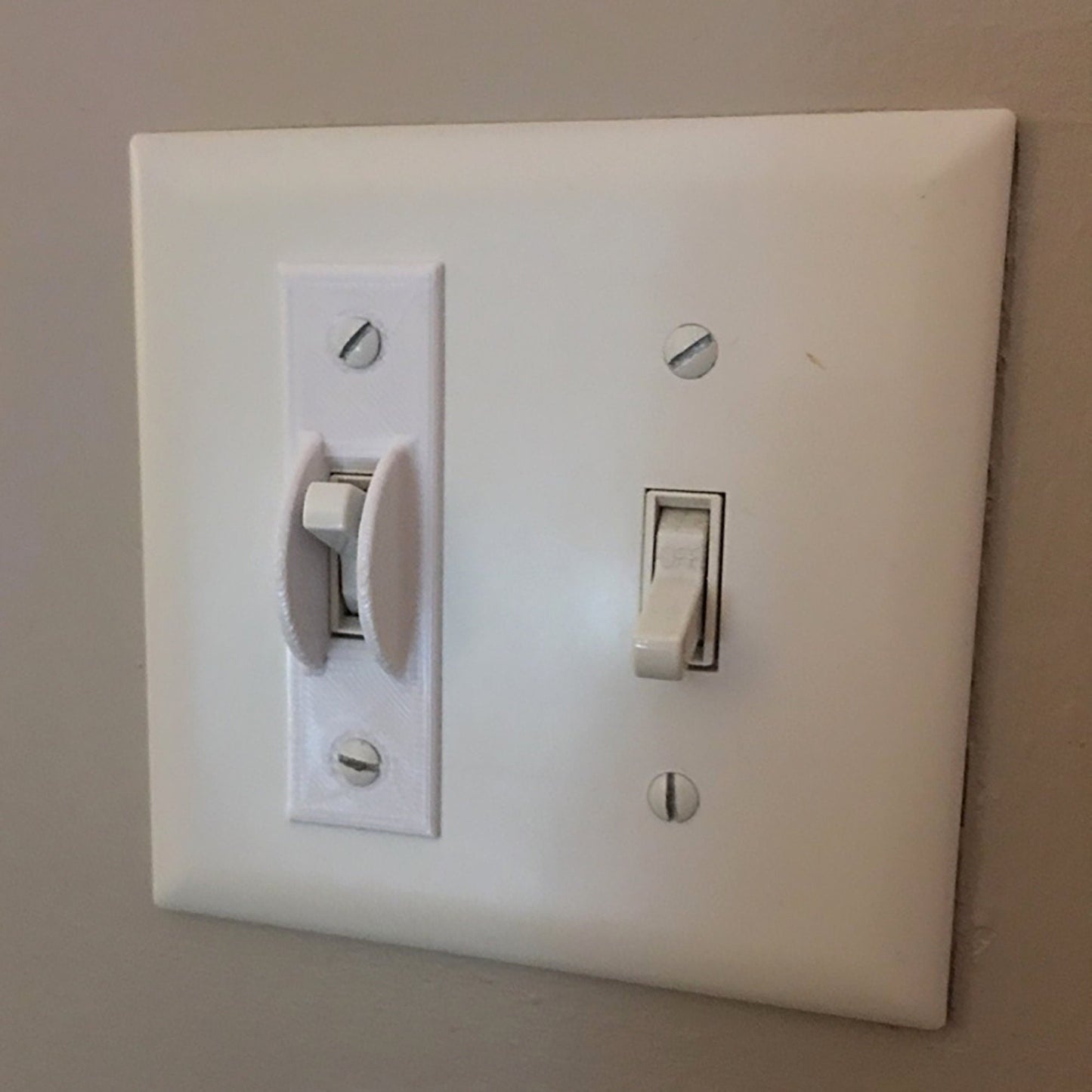 a white light switch sitting on top of a wall