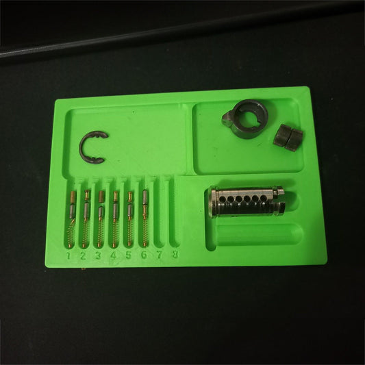 a green tool tray with various tools in it