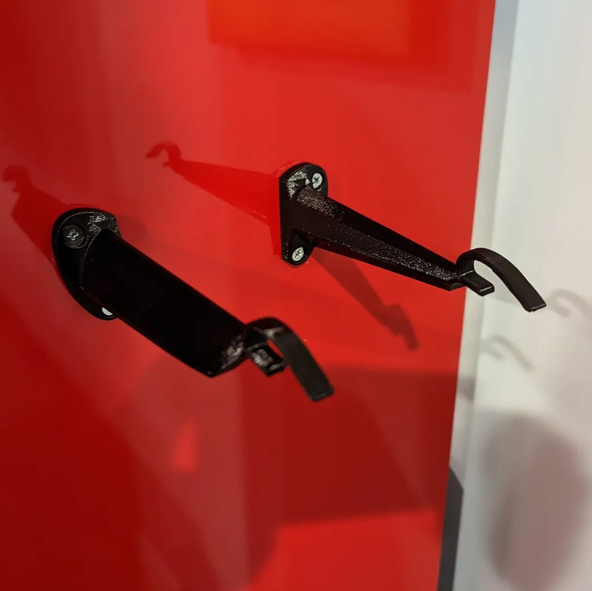 a pair of black handles on a red door