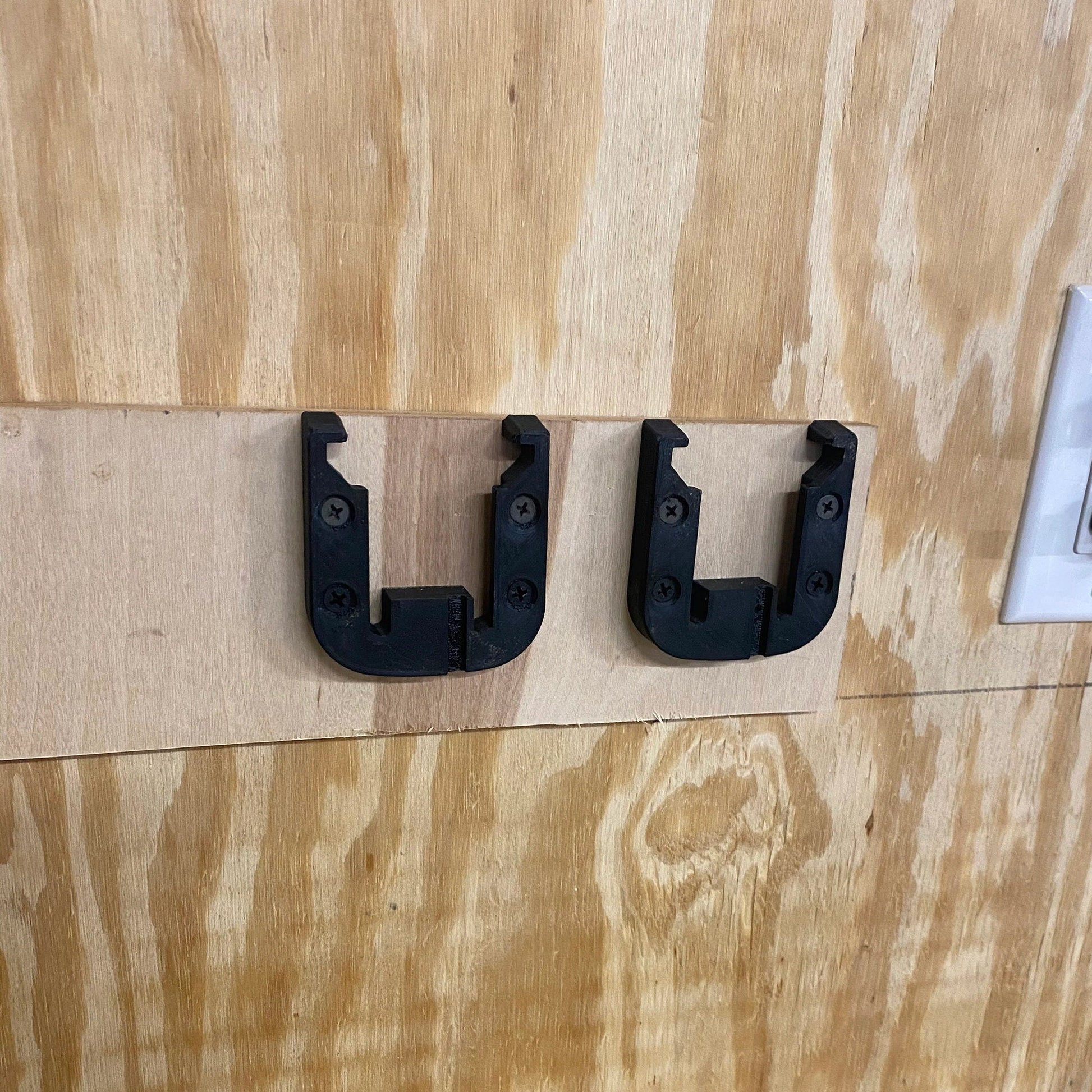 a couple of black handles on a wooden door