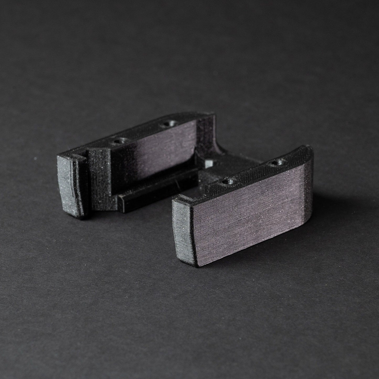 a pair of black and silver cufflinks on a black surface