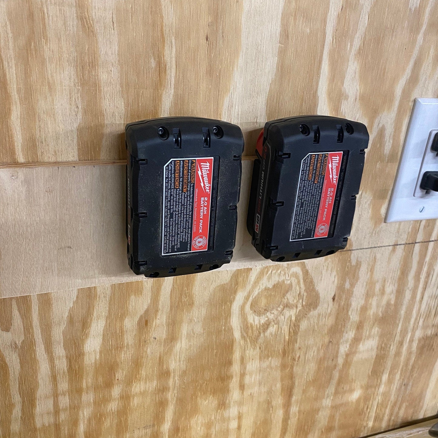 a couple of black batteries sitting on top of a wooden wall