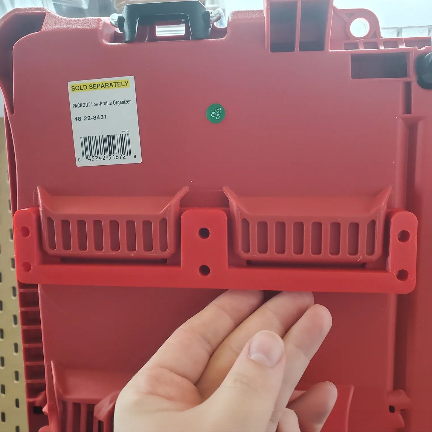 a person holding a red plastic container with a barcode on it