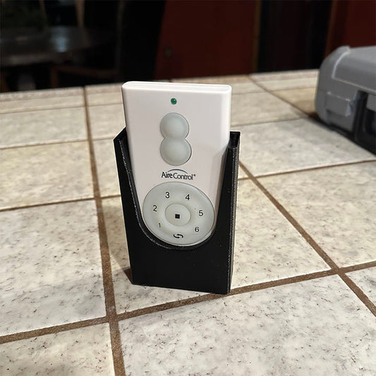 a white and black remote control sitting on a tile floor