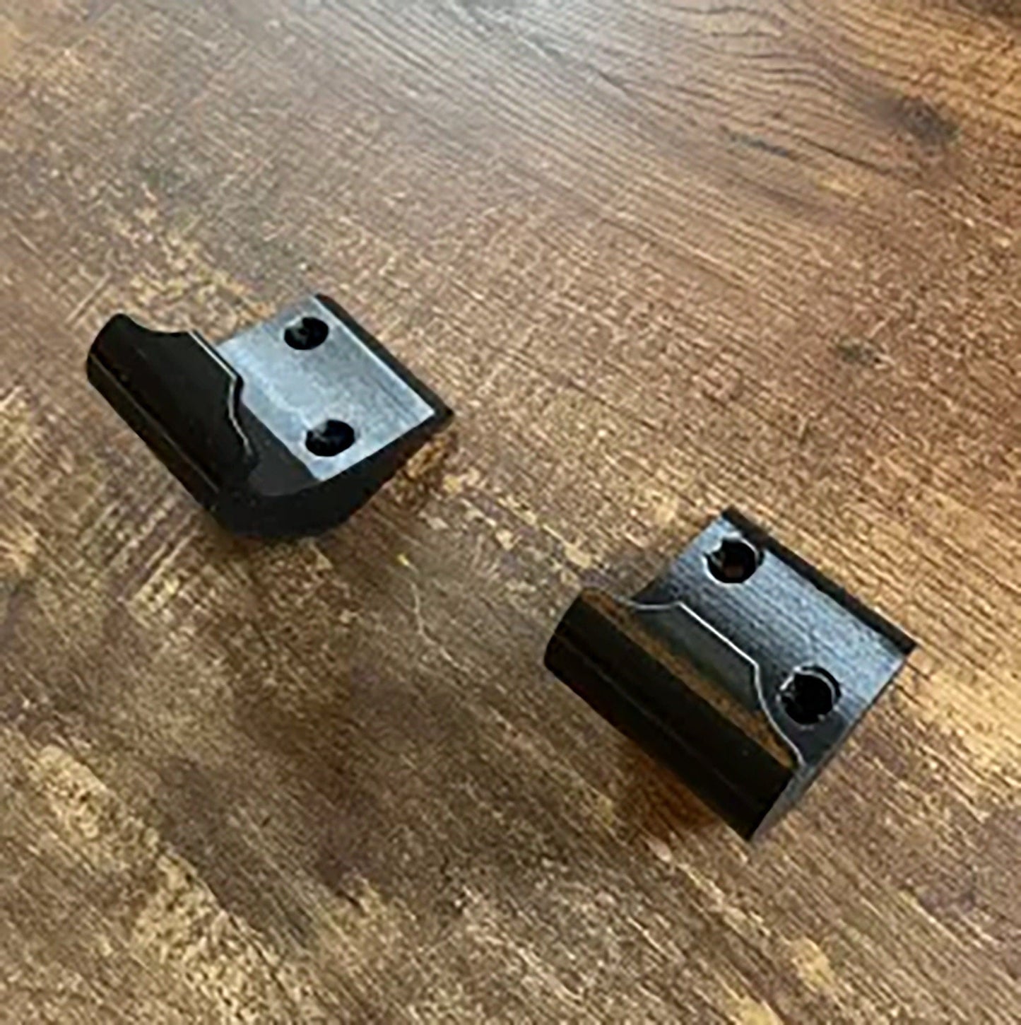 a couple of black brackets sitting on top of a wooden table