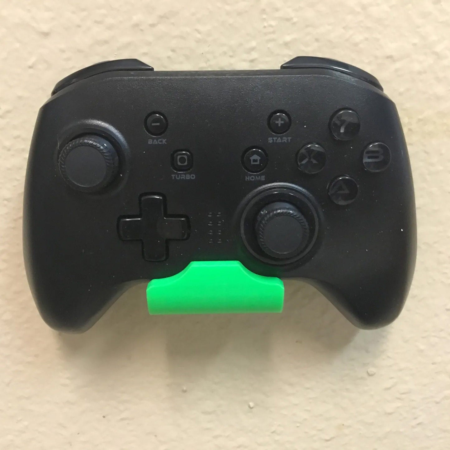 a close up of a game controller with a green handle