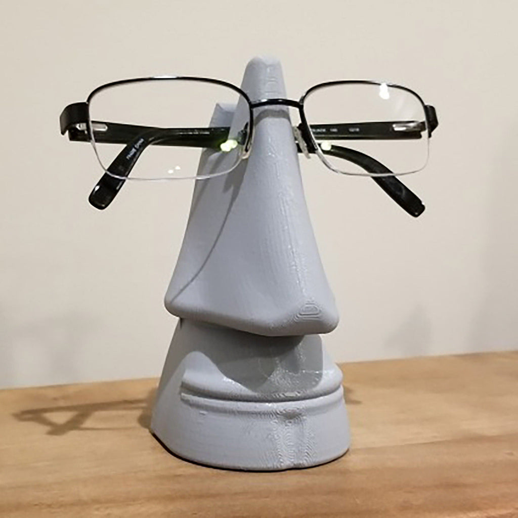 Nose shaped eyeglasses holder stand cradling a pair of glasses