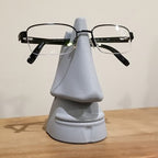 Nose shaped eyeglasses holder stand cradling a pair of glasses