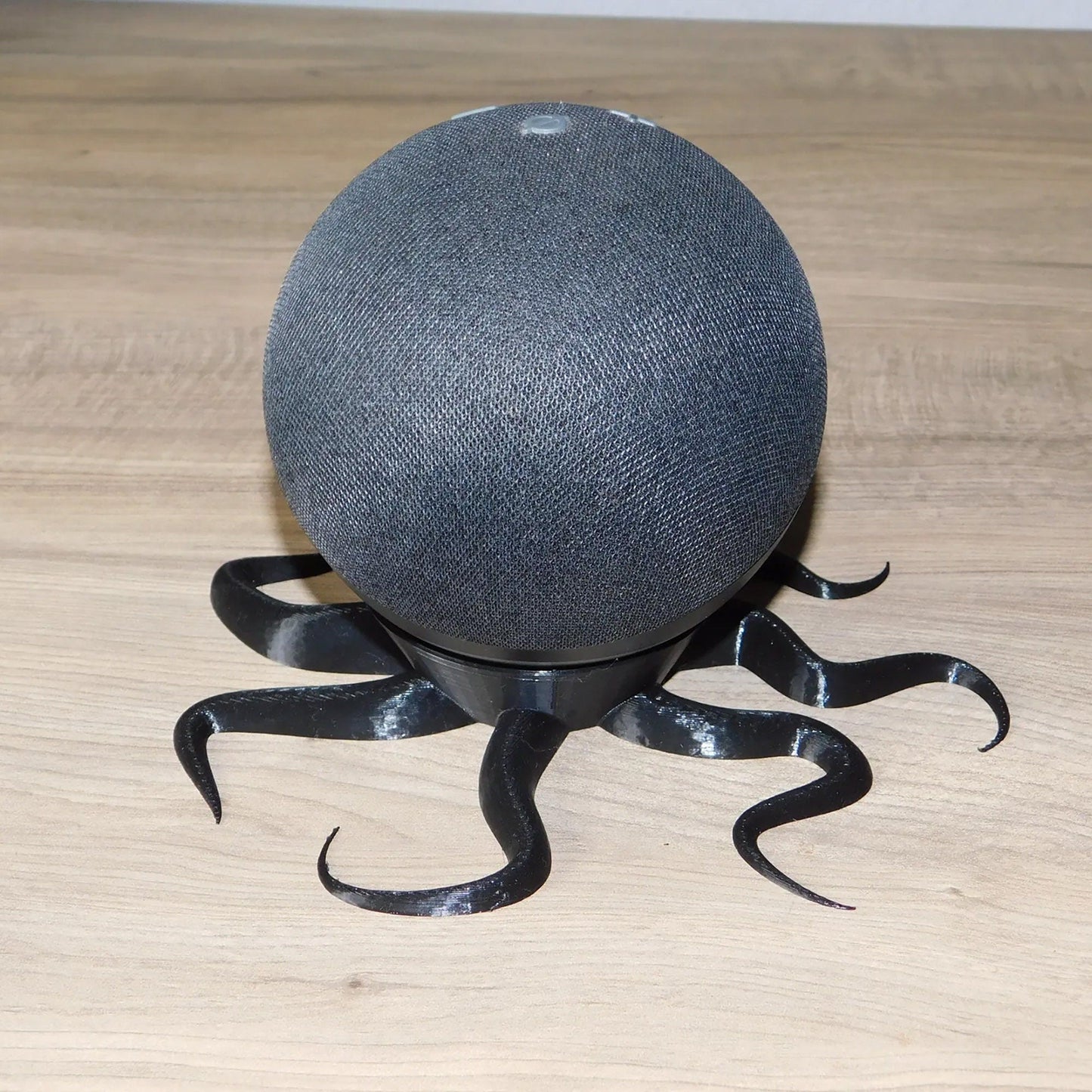 a black speaker sitting on top of a wooden table