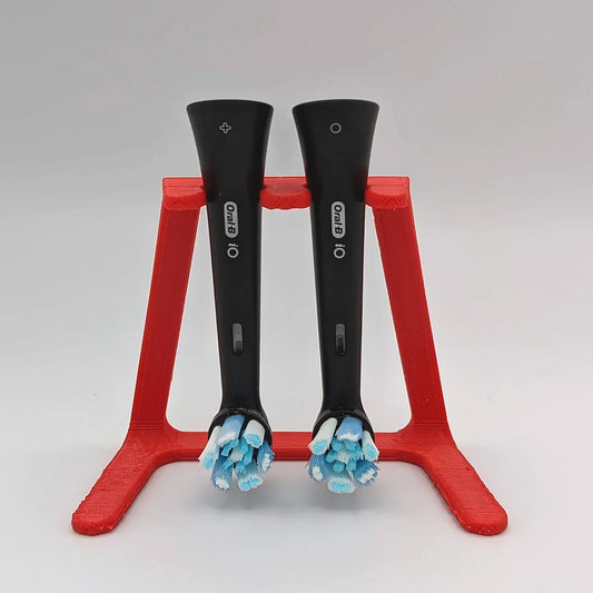 a pair of black and red scissors on a red stand