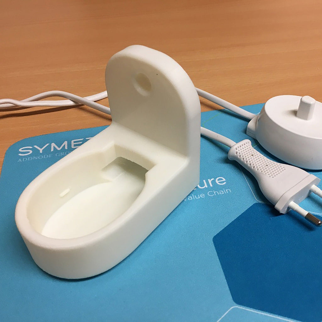 Wall mount holding an Oral-B toothbrush charging base with cable channel, view 2