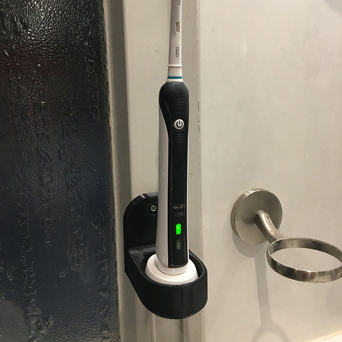 a black and white electric toothbrush sitting on a door handle