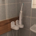 Wall mount holding an Oral-B toothbrush charging base with cable channel, view 4