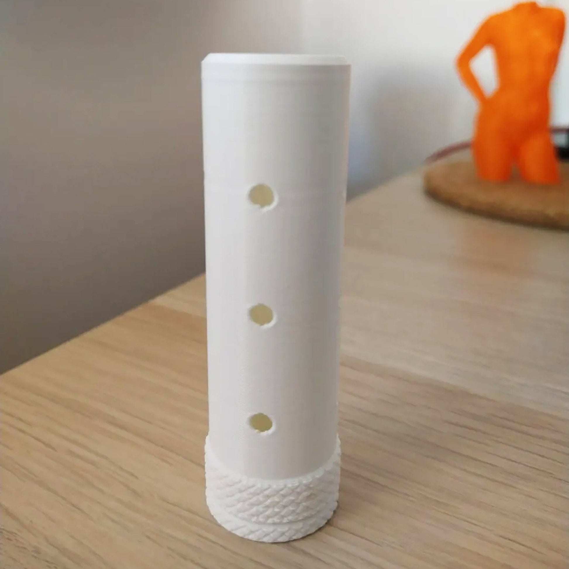 a white vase sitting on top of a wooden table