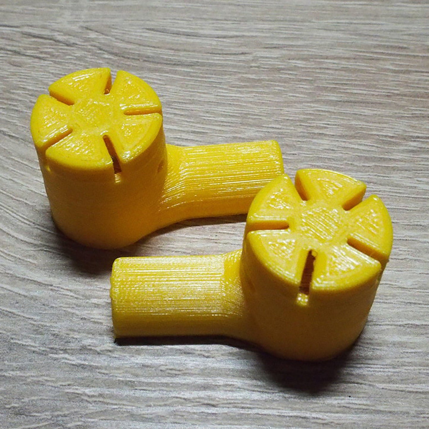 a couple of yellow plastic objects sitting on top of a wooden table