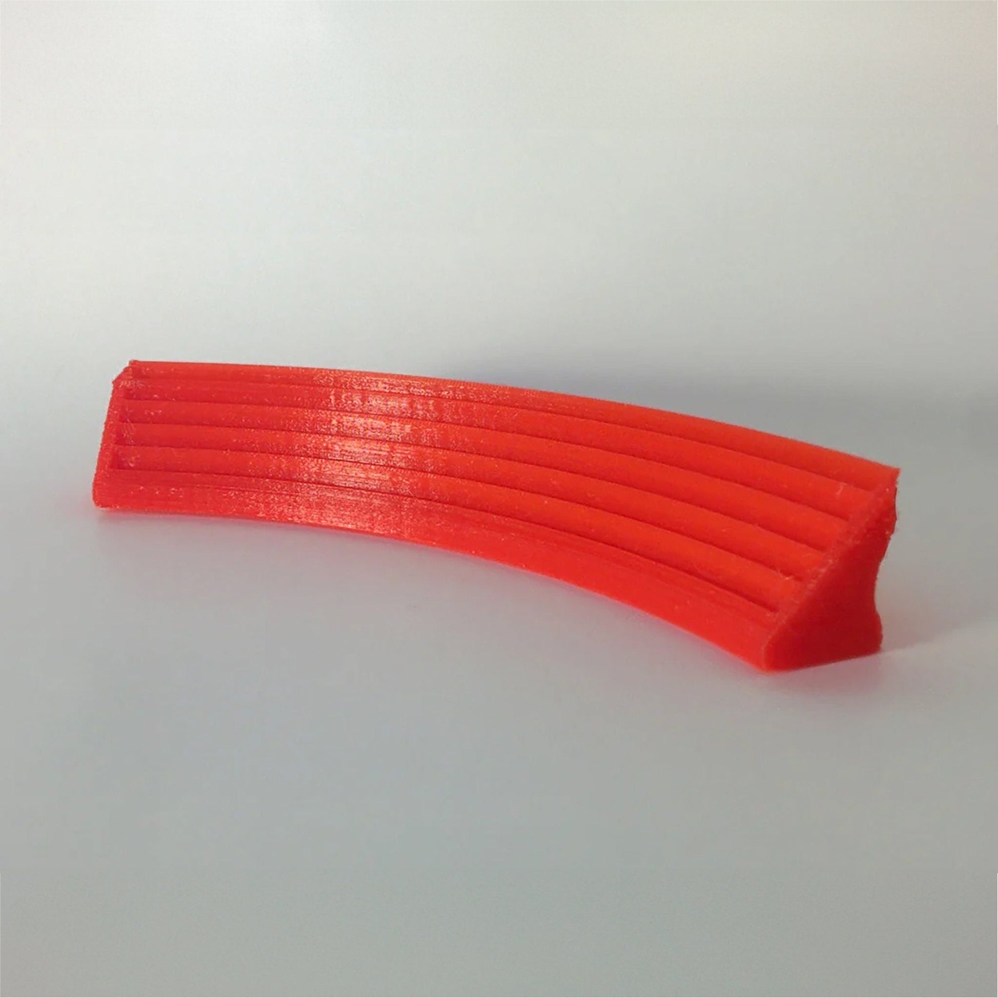 a stack of orange plastic strips sitting on top of a white table