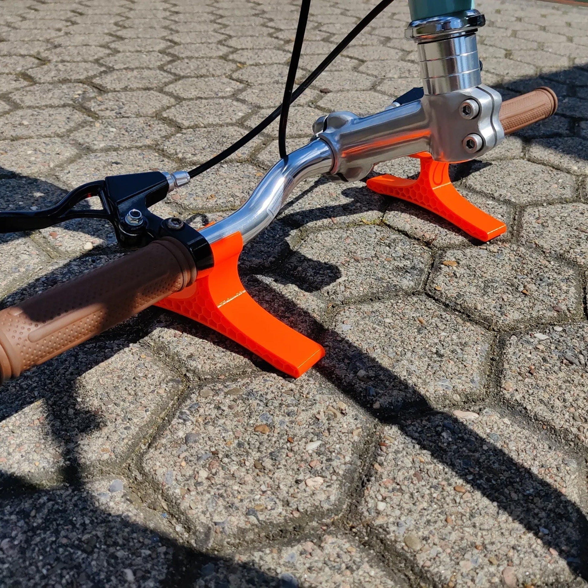 a close up of a bike handlebar on a cobblestone road