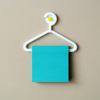 Mini coat hanger sticky note holder pinned to a cork board, view 2