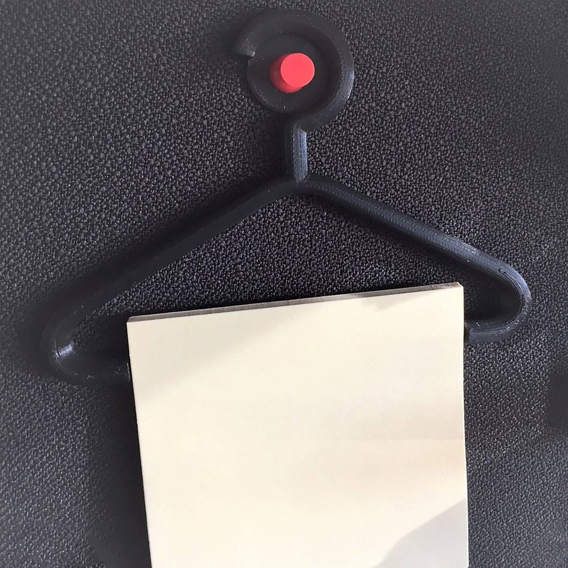 a piece of paper with a red button attached to it