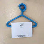Mini coat hanger sticky note holder pinned to a cork board, view 5