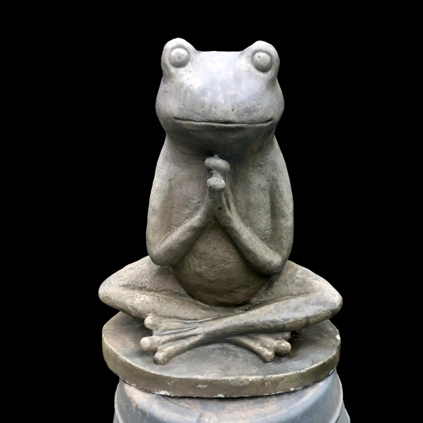 a statue of a frog sitting on top of a table