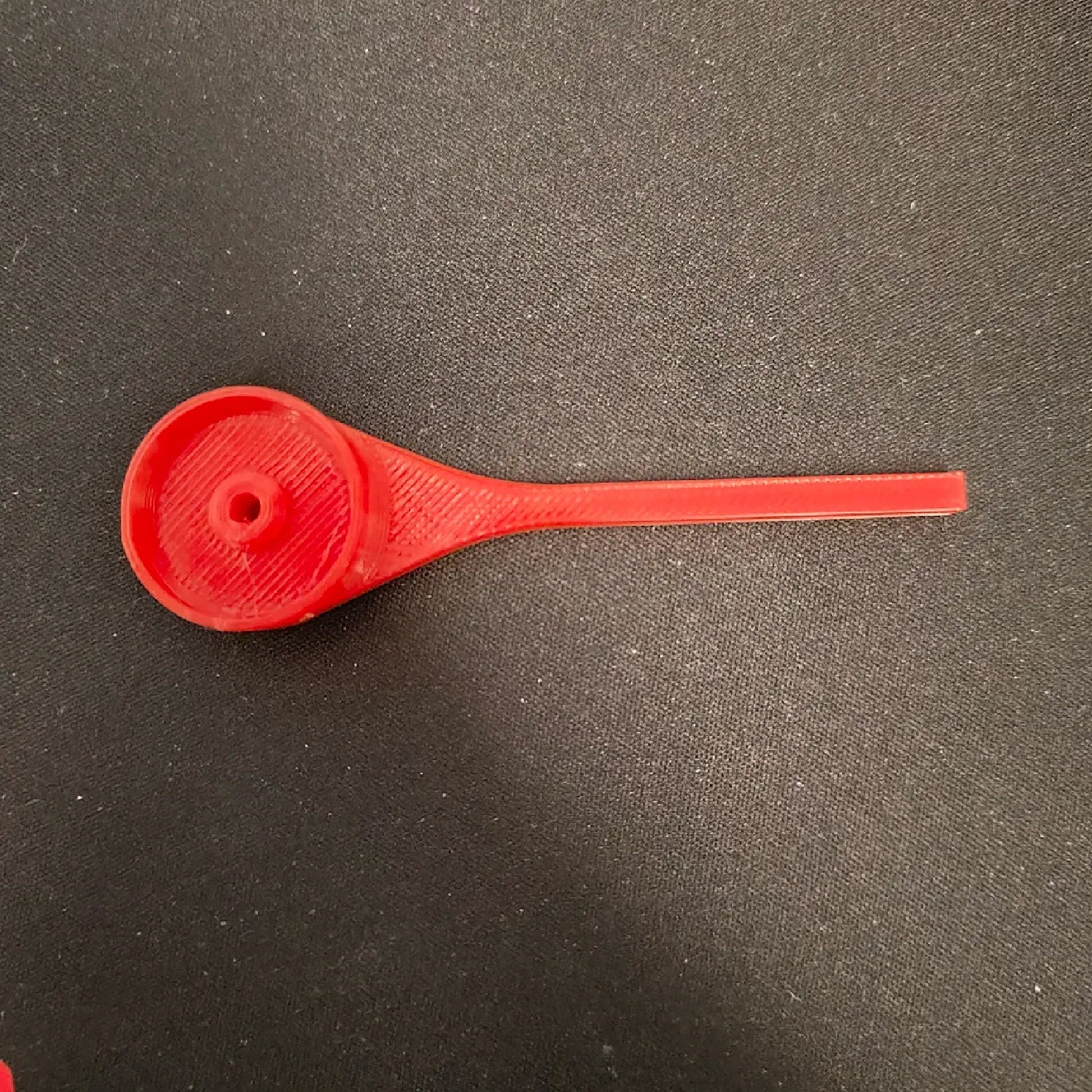 a red spoon sitting on top of a table