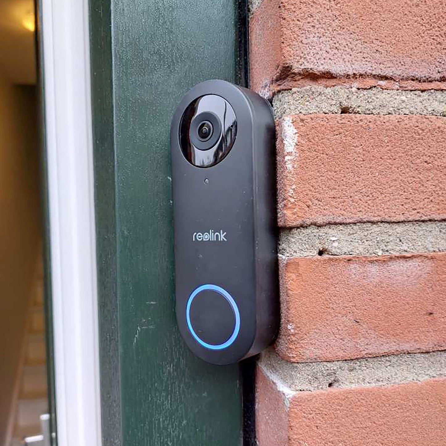 a camera mounted to a brick wall near a door