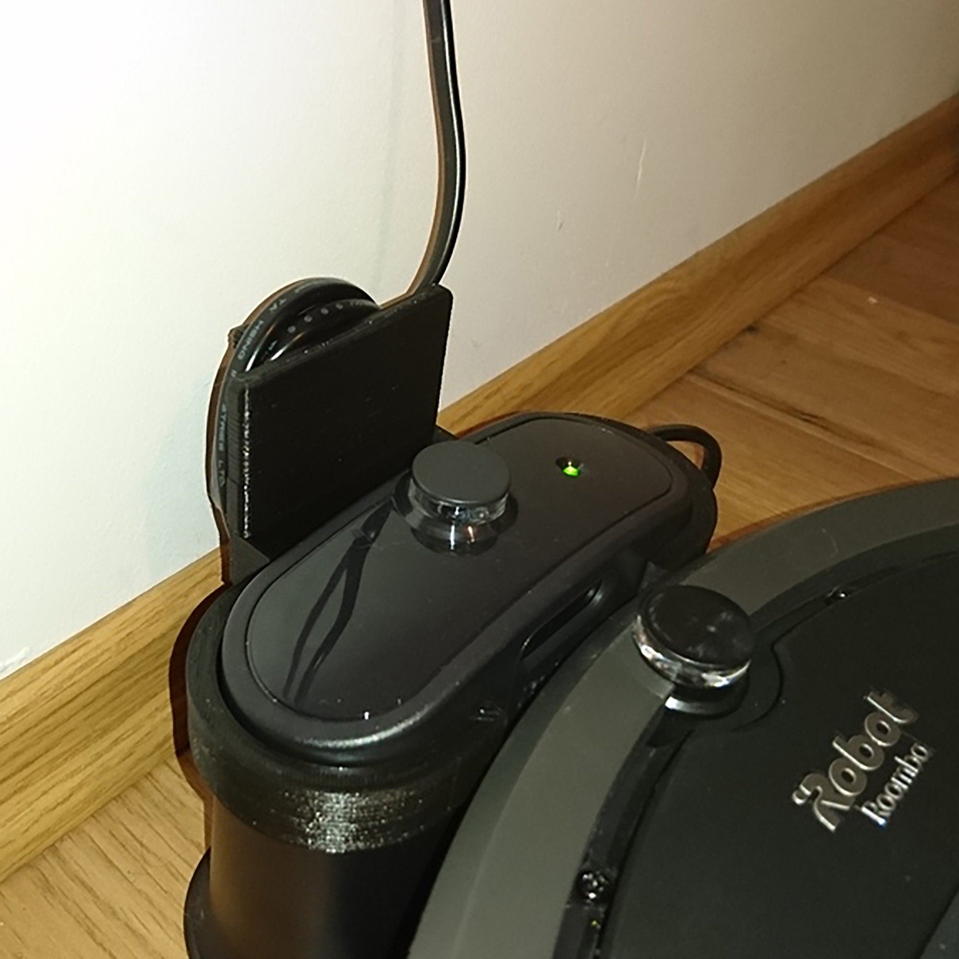 a close up of a robot vacuum on a wooden floor