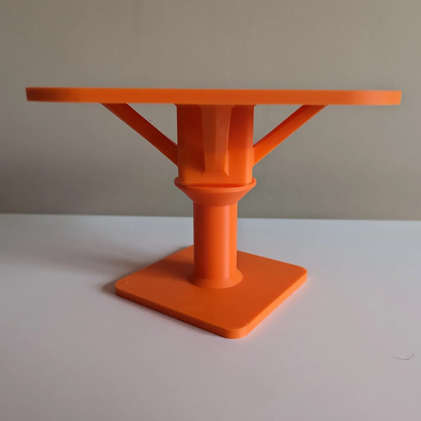 an orange plastic table on a white surface