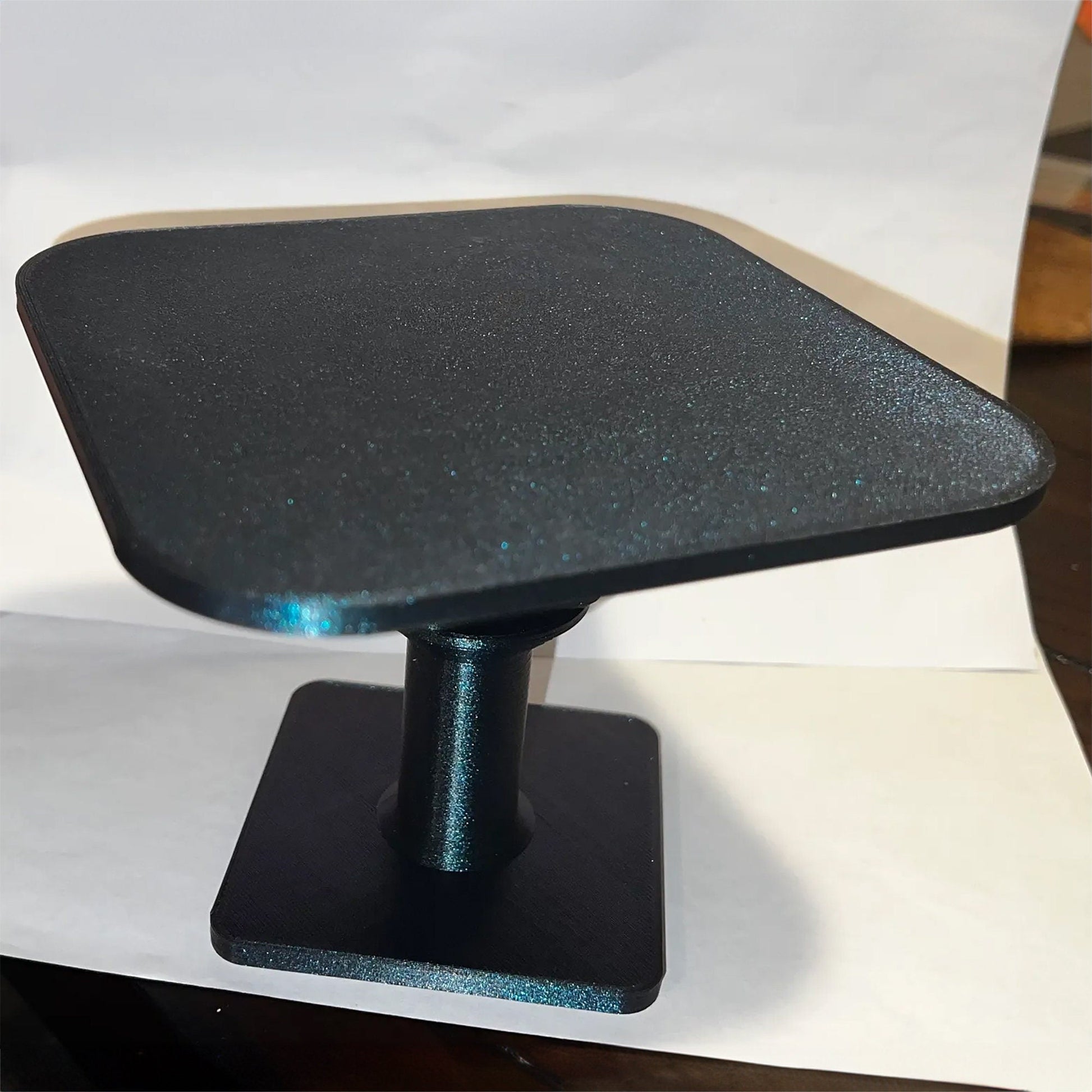 a black table top sitting on top of a white table