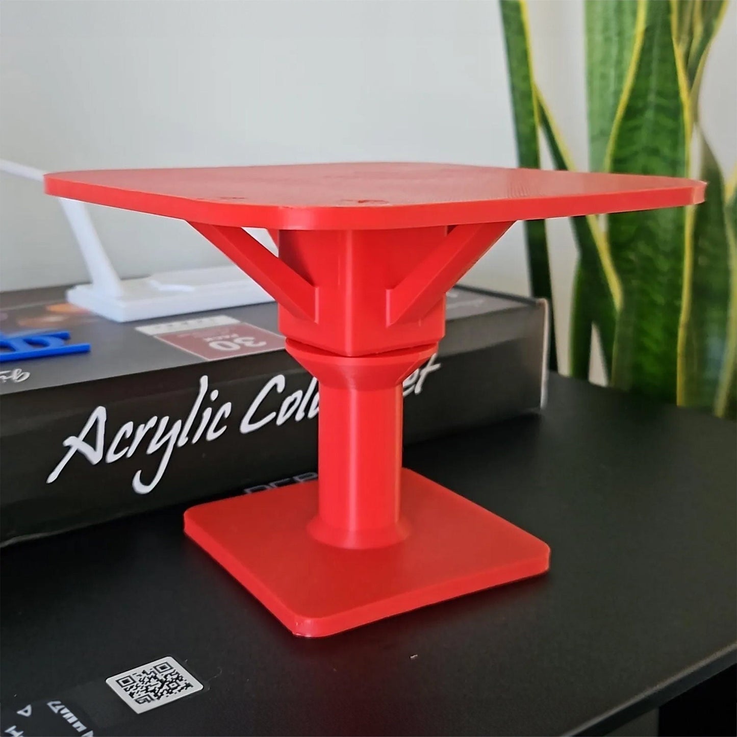 a red table sitting on top of a black table