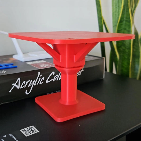 a red table sitting on top of a black table