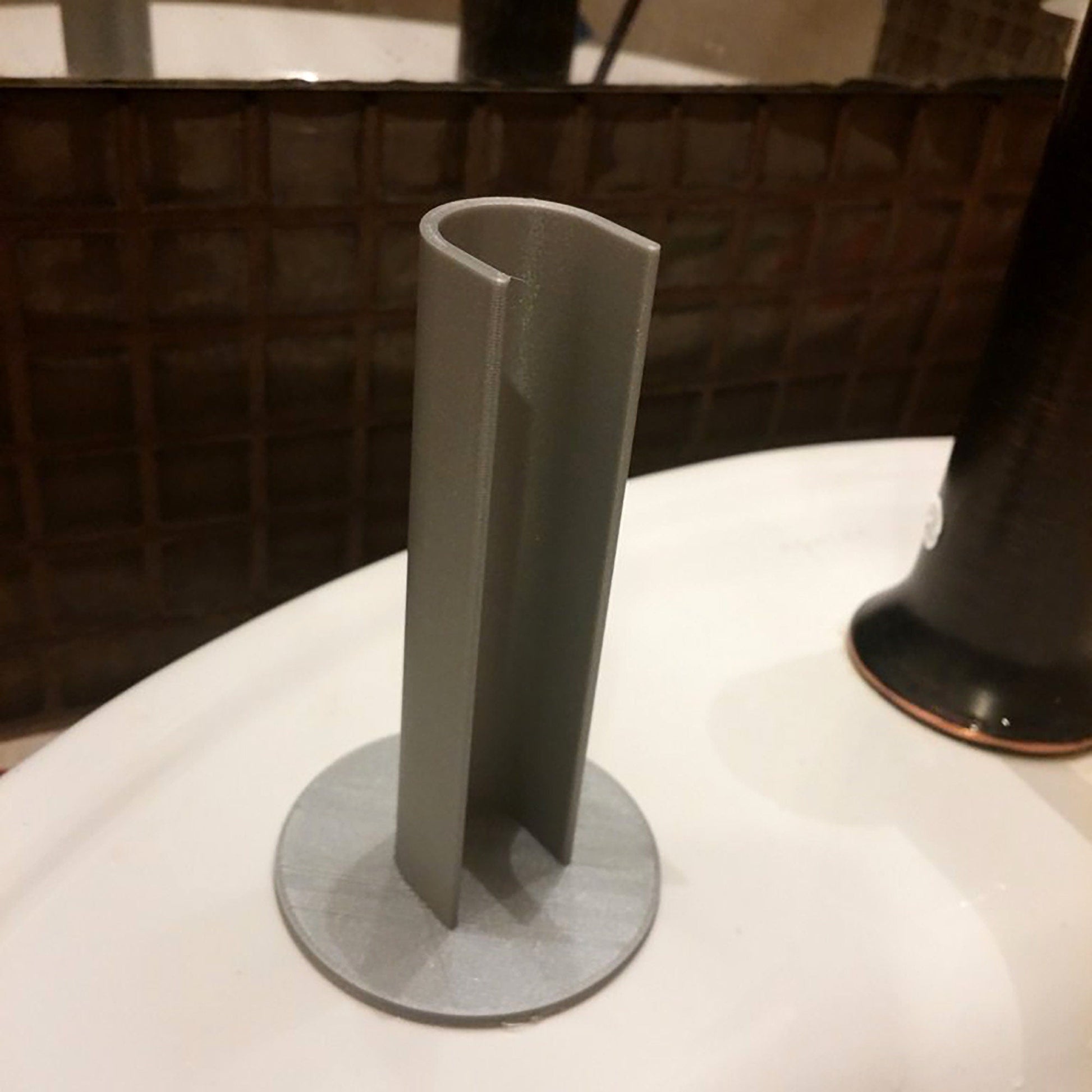 a white toilet with a black toilet brush