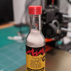 Salt shaker lid with seven holes screwed onto a hot sauce bottle, view 2