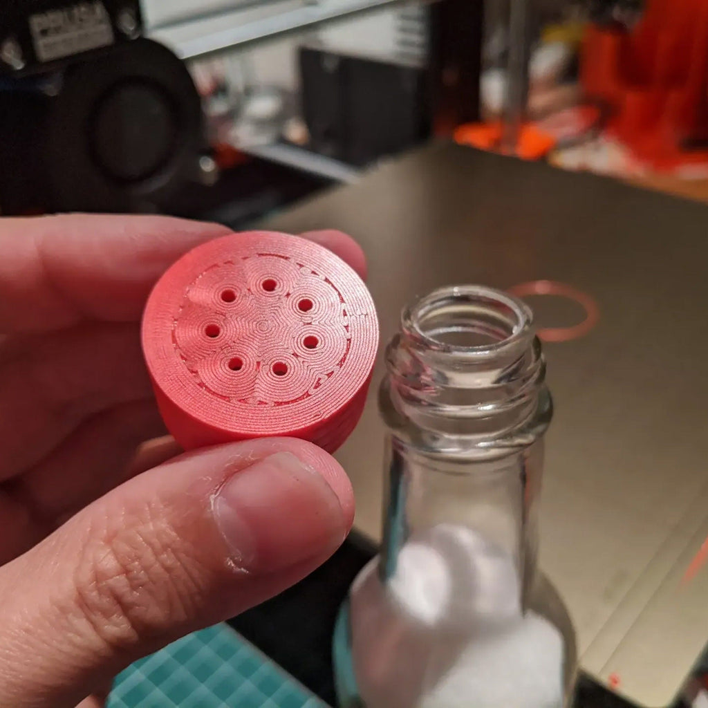 Salt shaker lid with seven holes screwed onto a hot sauce bottle